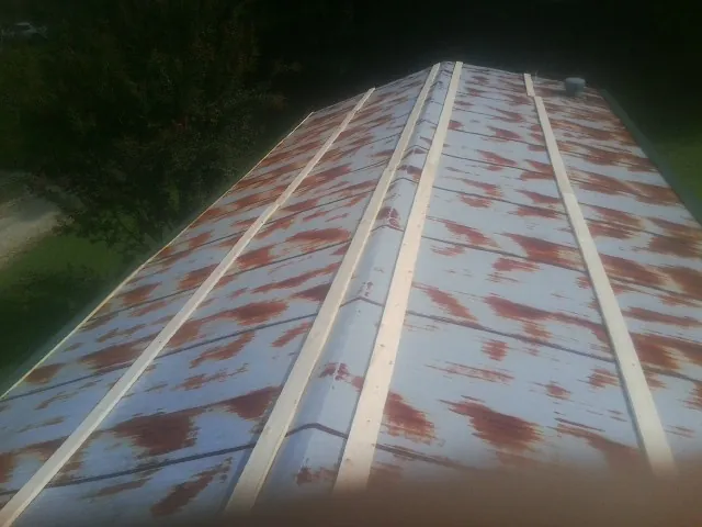 Rusted metal roof panels with new wood purlins before replacement — Storm Damage Roof Repair in Kendall Park by Roofing Brothers