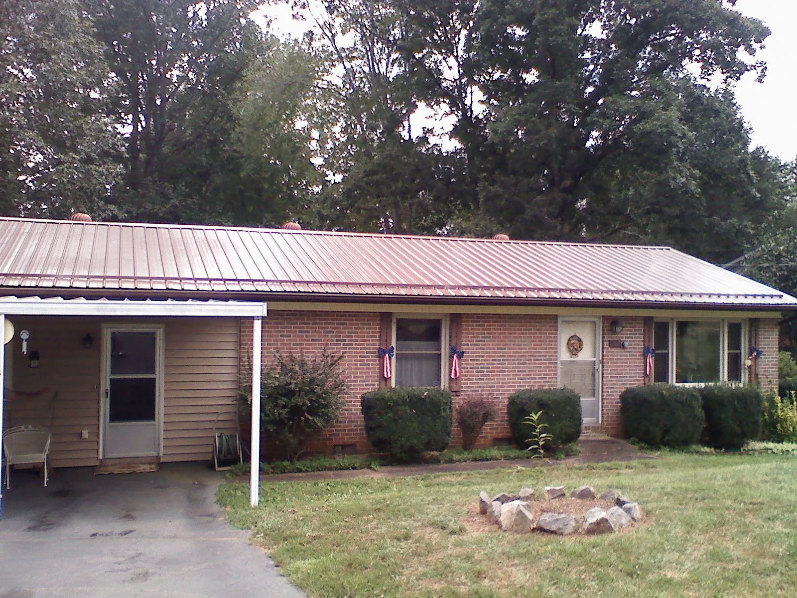 Bronze metal roof and carport on a brick ranch home — Roof Repair work by our crew in Kendall Park