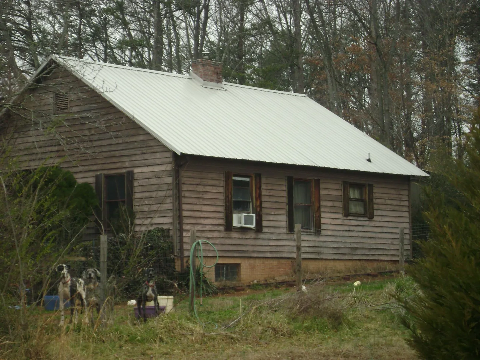 White metal roof on an old wood sided farmhouse, from a Metal Roof Installation job in Kendall Park